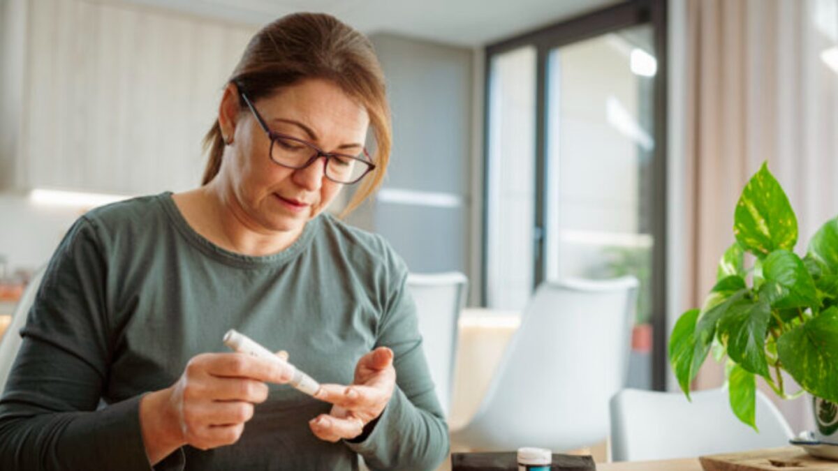 Mature diabetic woman using lancet on finger for checking blood sugar level by Glucose meter. High resolution 42Mp indoors digital capture taken with SONY A7rII and Zeiss Batis 40mm F2.0 CF lens