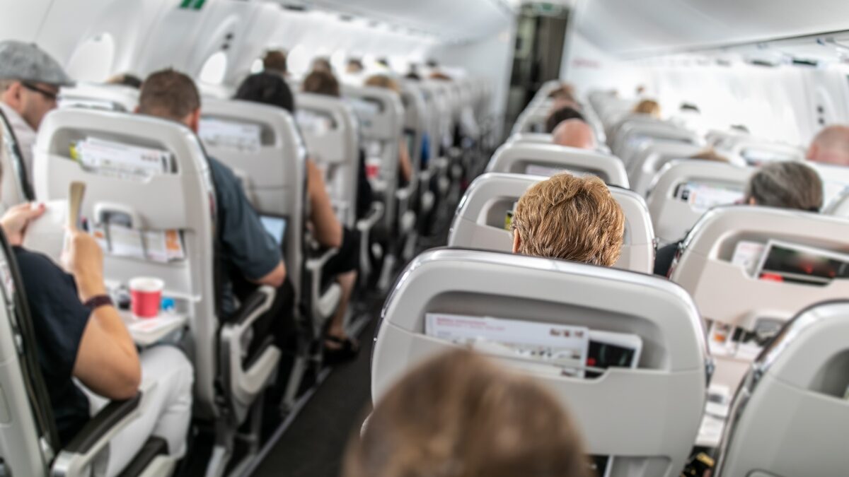 Interior of commercial airplane with passengers in their seats during flight.