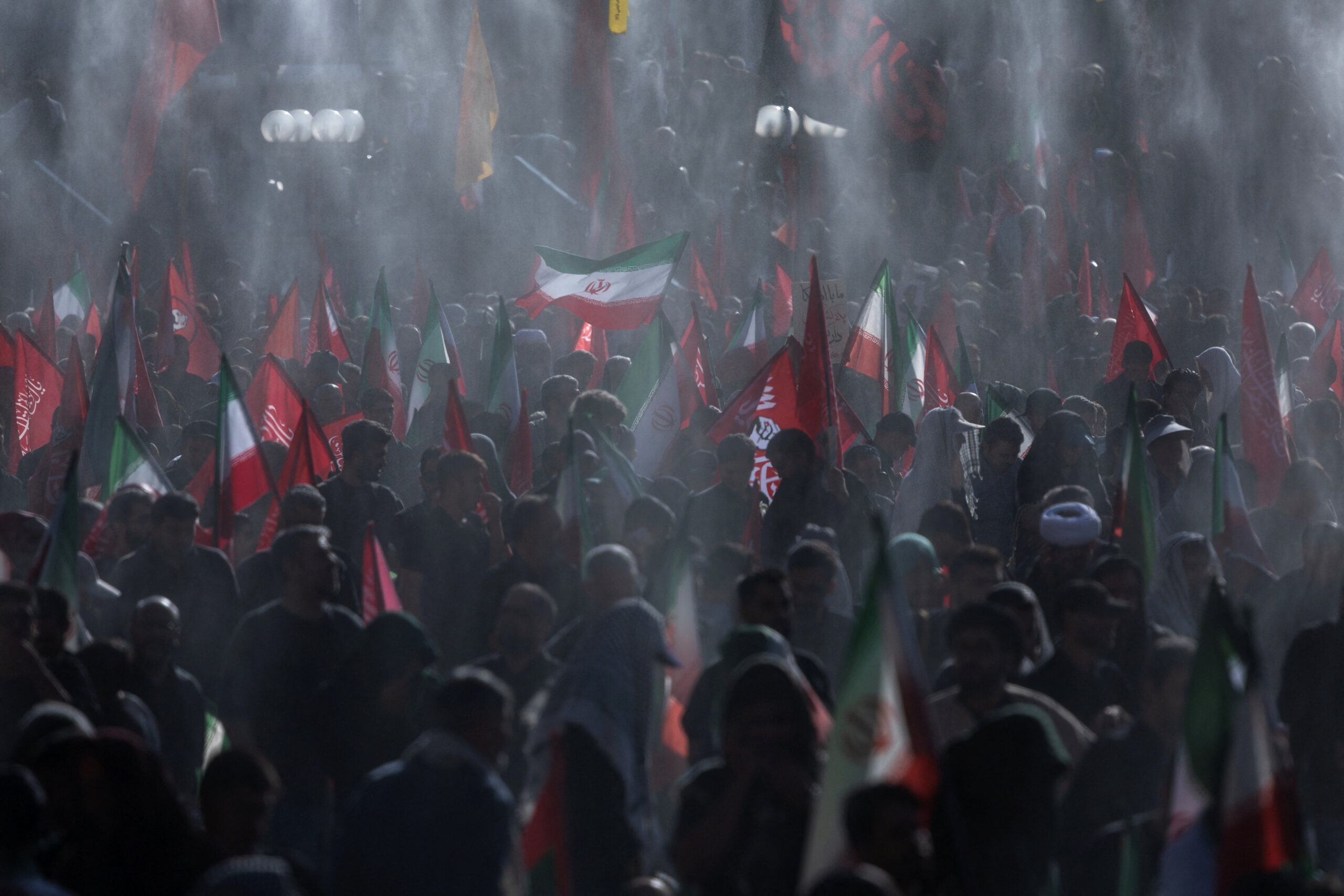 Mourners wave flags under water sprinklers during a public farewell ceremony to pay their respects to late Supreme Leader Ayatollah Ali Khamenei, who was killed on February 28 in Israeli and U.S. airstrikes, at the Imam Khomeini Grand Mosalla, in Tehran, Iran, July 5, 2026. REUTERS