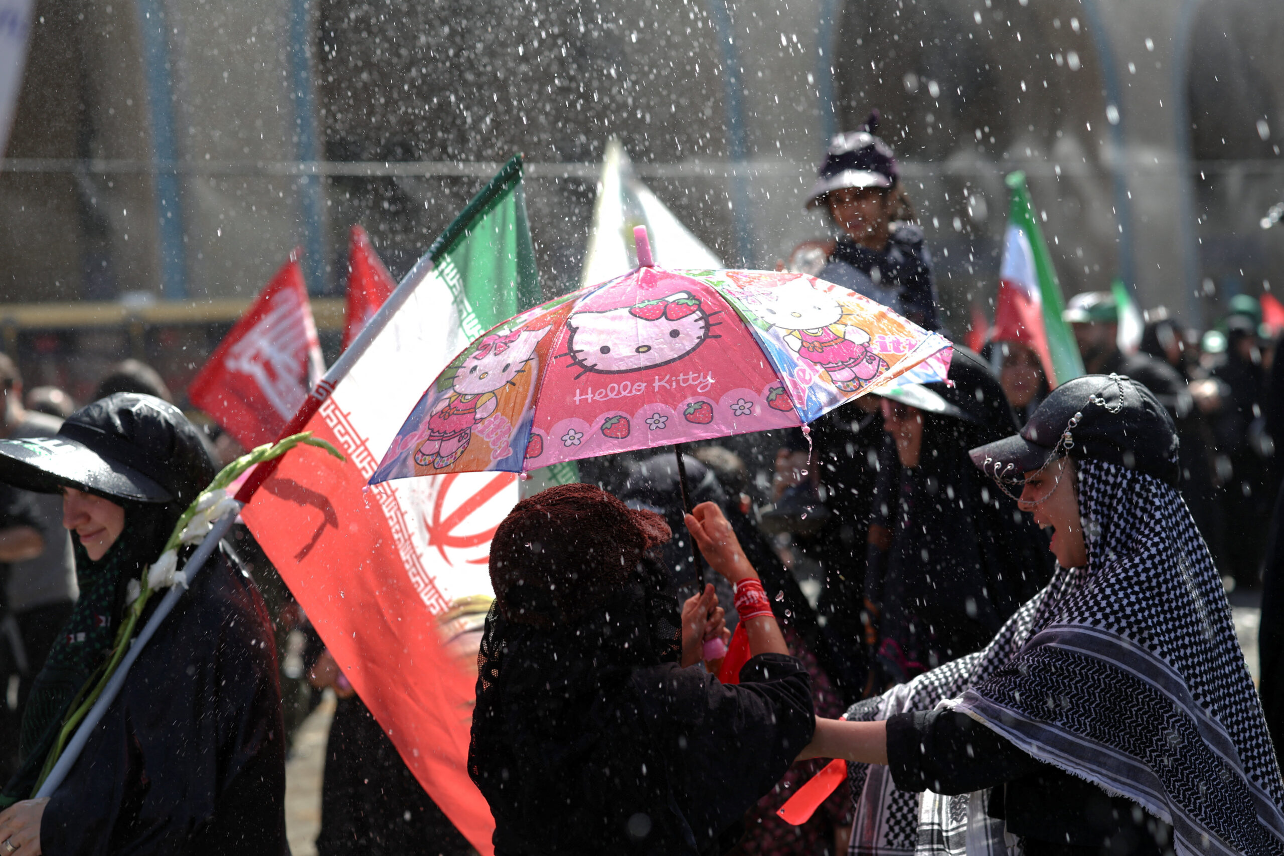 People cool themselves under sprayed water as they attend a public farewell ceremony to pay their respects to late Supreme Leader Ayatollah Ali Khamenei, who was killed on February 28 in Israeli and U.S. airstrikes, at the Imam Khomeini Grand Mosalla, in Tehran, Iran, July 5, 2026. REUTERS