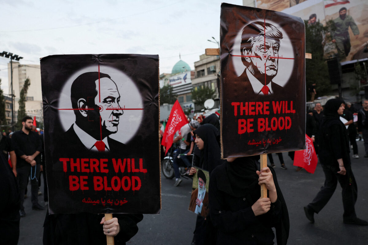 Mourners hold signs with depictions of U.S. President Donald Trump and Israeli Prime Minister Benjamin Netanyahu, on the day of a funeral procession for Iran's late Supreme Leader Ayatollah Ali Khamenei, who was killed on February 28 in Israeli and U.S. airstrikes, in Tehran, Iran, July 6, 2026. REUTERS