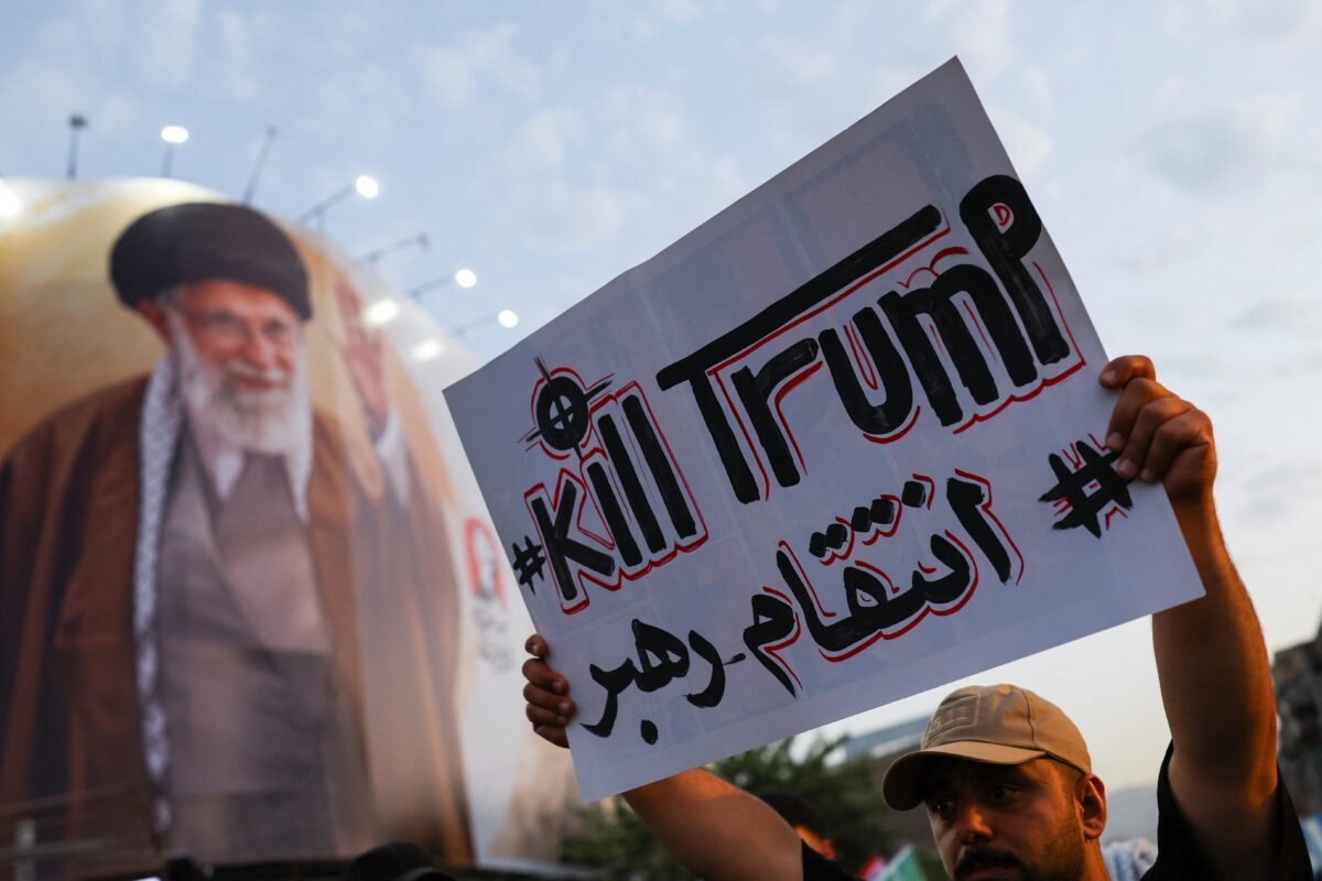 A mourner holds a sign ahead of a funeral procession for Iran's late Supreme Leader Ayatollah Ali Khamenei, who was killed on February 28 in Israeli and U.S. airstrikes, in Tehran, Iran, July 6, 2026. REUTERS