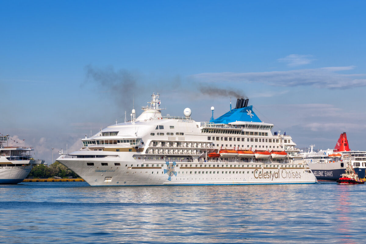 Cruise liner in a seaport near Athens. White passenger ship calling at the sea harbor. Large tourist cruise in summer. Concept of vacation and traveling.