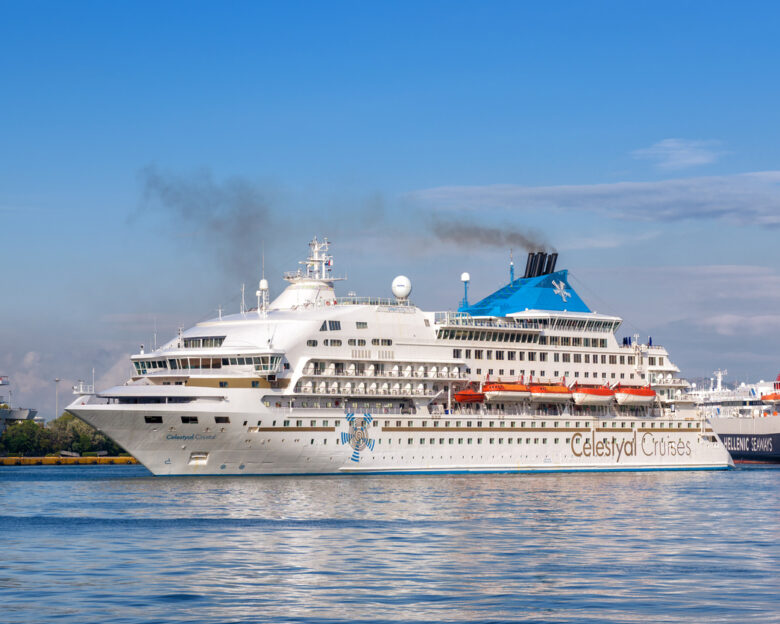 Cruise liner in a seaport near Athens. White passenger ship calling at the sea harbor. Large tourist cruise in summer. Concept of vacation and traveling.