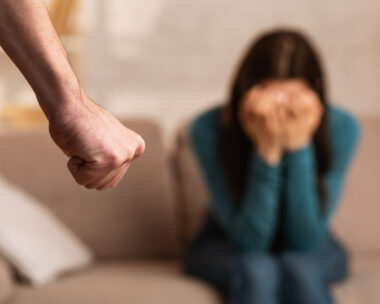 Domestic Violence During Quarantine. Man threatening his girlfriend with fist, scared woman hiding her face in hands