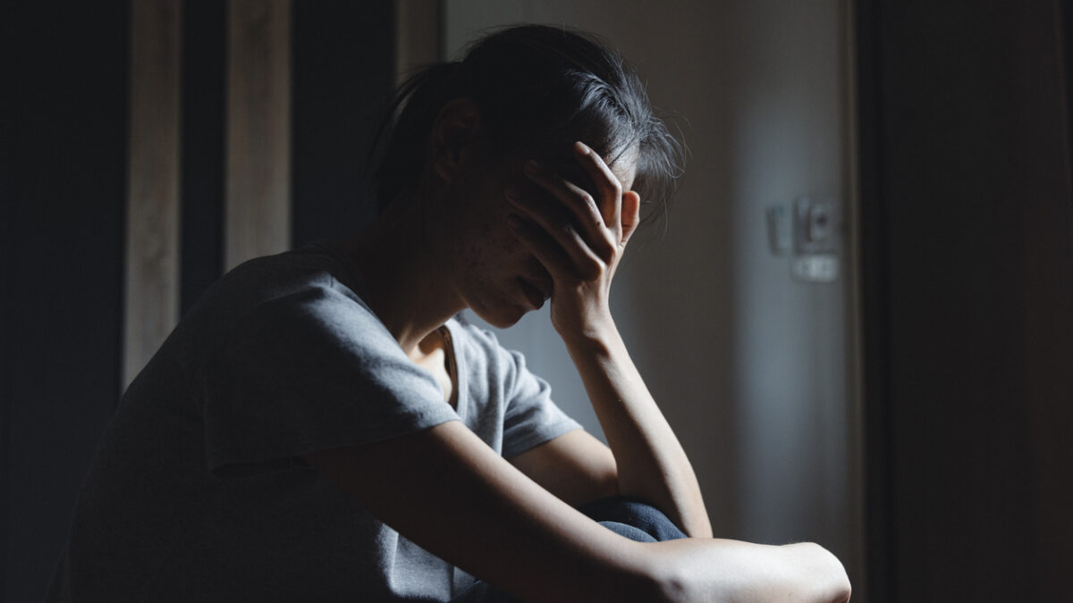 Sad woman sitting alone, woman on the bed, stress, suicidal thoughts, human trafficking
