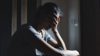 Sad woman sitting alone, woman on the bed, stress, suicidal thoughts, human trafficking