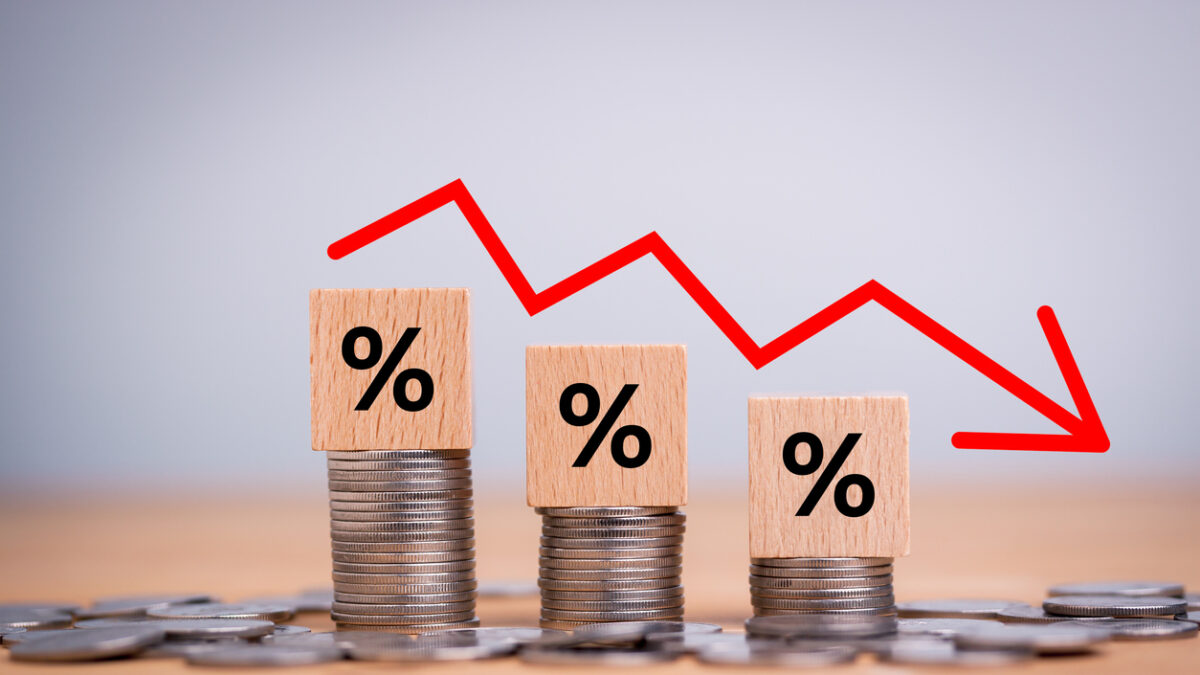 Percentage sign on wooden cubes with Stack of coin bar chart and red graph trending downwards on white background. Economy recession crisis, inflation, stagflation, business and financial loss concept