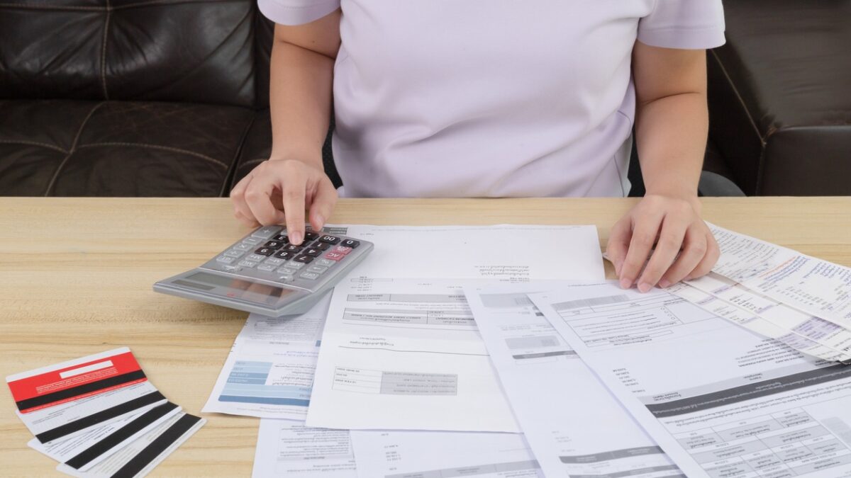Young woman pressing the calculator for calculate the money for her dept. Asian women are stressed about payment loan problem. people with personal financial crisis concept. Debt, loan concept.