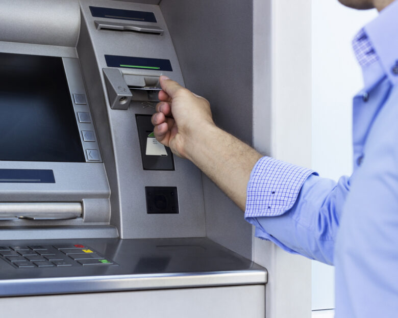 Hand of man with credit card, using a ATM