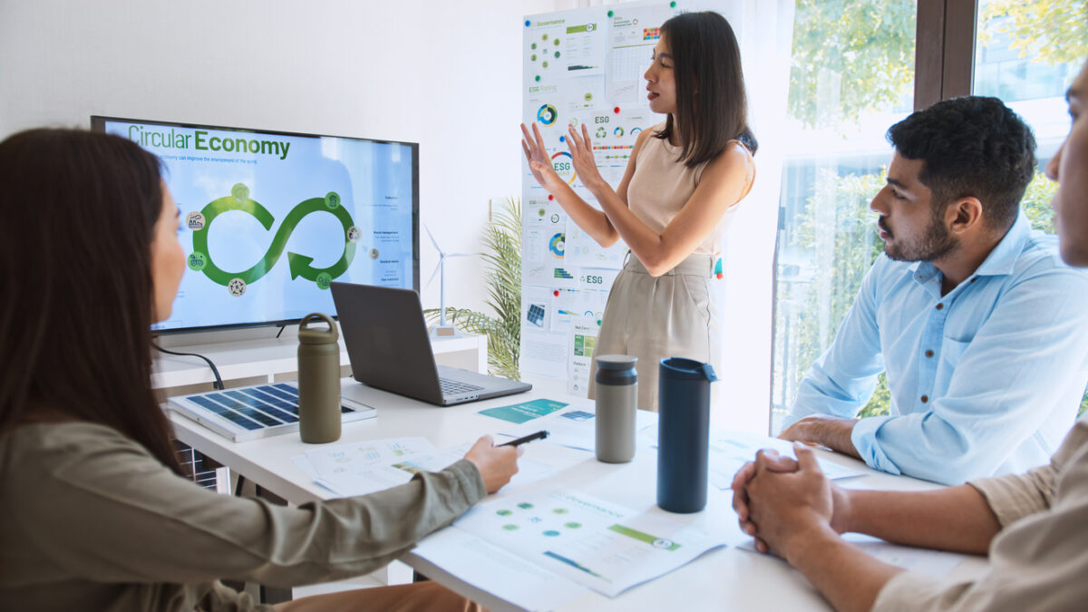 Asian woman lead young group of multiethnic businesspeople in team meeting, using laptop computer for ESG topic presentation on monitor. Sustainable business practice, people work at home concept