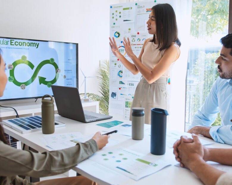 Asian woman lead young group of multiethnic businesspeople in team meeting, using laptop computer for ESG topic presentation on monitor. Sustainable business practice, people work at home concept