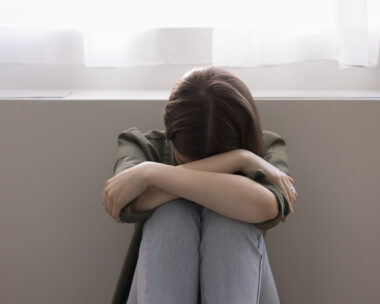 Unhappy lonely adolescent girl suffers from bullying at school, hiding face, feels depressed, hopeless, offended, think about personal problem, worried about lack of communication. Teenage concerns