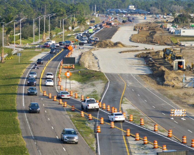 Driving traffic cars on road under construction. Building traffic infrastructure on American roadway with moving cars. SSUCv3H4sIAAAAAAAACoxSPW/kIBDtI+U/rKizkg2OvU6b6orrrotSjIFbo2XB4iOnKNr/nsGYhI3uTumYN28+3jzebm92OzKBV5w87N5ShLHSOvrgIChrEG7uNtxJI6SrkRfH+qYGQNWRFCpYp0DX4ASBzwbOEkETtU7wZU0SHyBEL321i59jCNL5YPkJYVaxOQR5xPZX/KLlKce7kliTWIEp8sOIpC/ttS2VR8UpZR+twWTkq/qSziP/0e+XA+MX63D7VPOXnj+V51JrMNJG/9k0P54/jneUhr8mMZdKppNaQj7KU6aS0x88yXmVvZEgCmWrM7xYDtp/ORioBRxc1S1OcWWOFWLDvHpcOnEbTXBpK0IpLeKItnaBSScTf+MkWfAZvMcKUfDaLzy6PVejjA2rLJK7EoGGprBl7HCgLe27tmPj2NyzjZD/x6ywz7pR2TEu2oKQaeiHPV9/Tjt0bGDDOPSZURxNFp0VMr9RfehbulVf/VrkKPGfX0to3wwoaKT3q/lboUojSTc2kote7gWd2L6TIPbjQKf9oaPt0PRAGQxYdXkHAAD//wMA/mDfAKwDAAA=