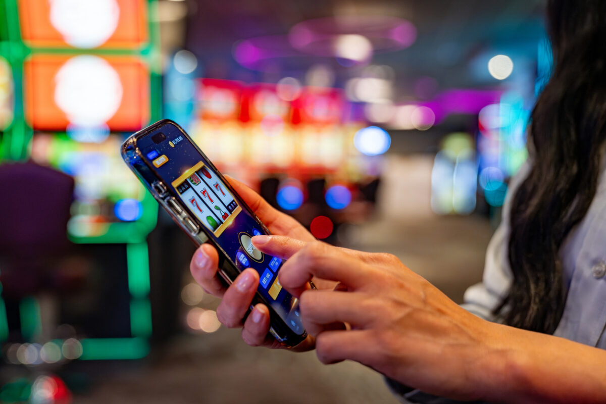 Close-up on a woman playing games on her cell phone at a casino - leisure game concepts