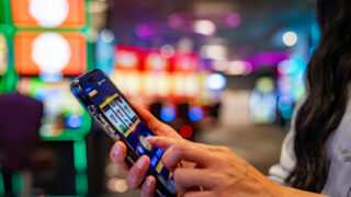 Close-up on a woman playing games on her cell phone at a casino - leisure game concepts