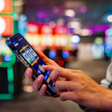 Close-up on a woman playing games on her cell phone at a casino - leisure game concepts
