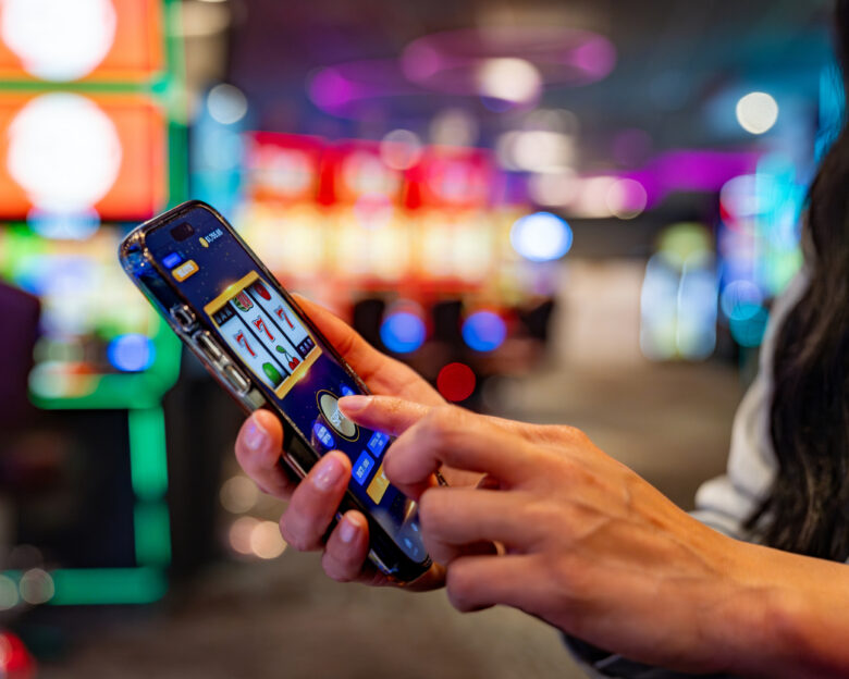 Close-up on a woman playing games on her cell phone at a casino - leisure game concepts