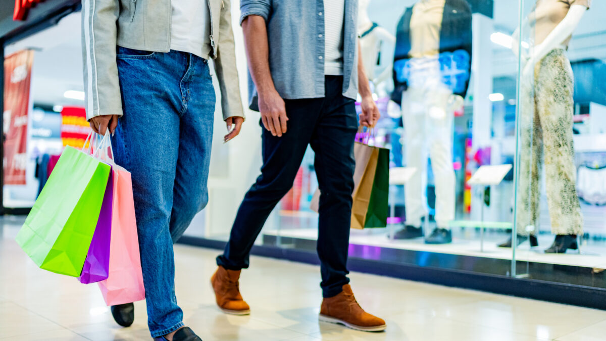Low section of couple walking with shopping bag atmall