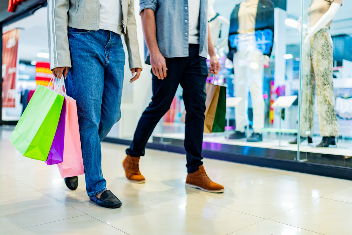 Low section of couple walking with shopping bag atmall