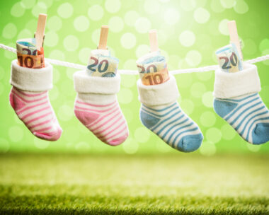 Two Pair Of Baby Sock With Dollar Hanging On Rope Using Wooden Clip