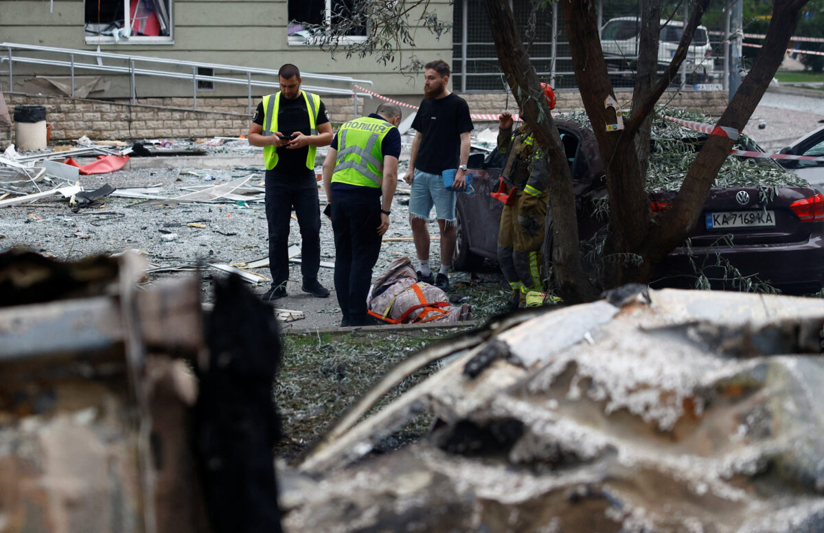 Police officers look at the body of a killed resident at the site of an apartment building, which was heavily damaged during Russian missile and drone strikes, amid Russia's attack on Ukraine, in Kyiv, Ukraine, July 6, 2026. REUTERS