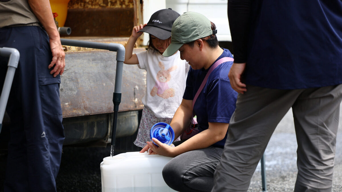 Yuka Shimada (45) and her daughter Tsugumi (3) receive water aid due to a water supply outage caused by an earthquake with a magnitude of 7.1 struck Japan's southern Kumamoto prefecture, at a community center in Yatsushiro, Japan, July 30, 2026. REUTERS/Issei Kato