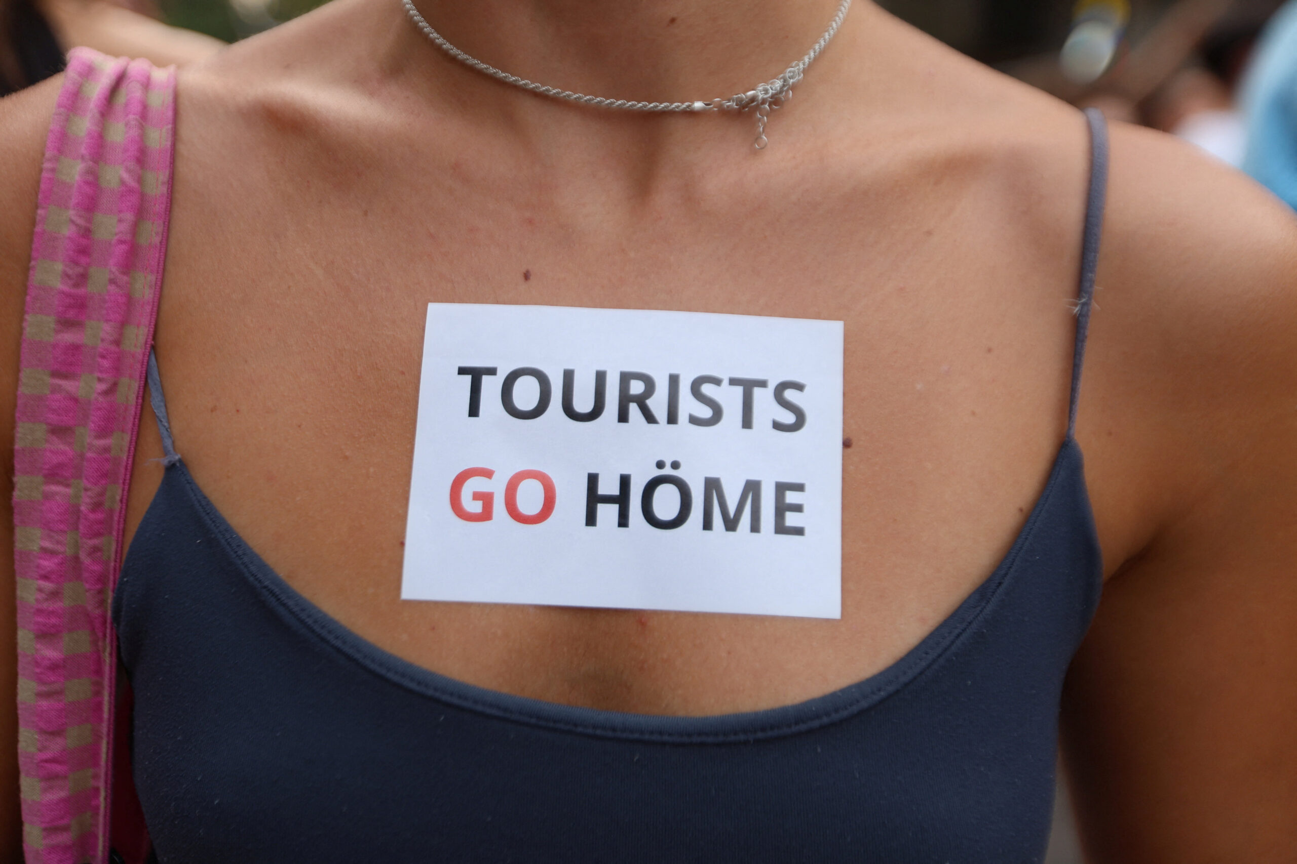 A demonstrator with a sticker on her chest attends a protest against mass tourism and gentrification in the Balearic Islands, in Palma de Mallorca, Spain, July 26, 2026. REUTERS