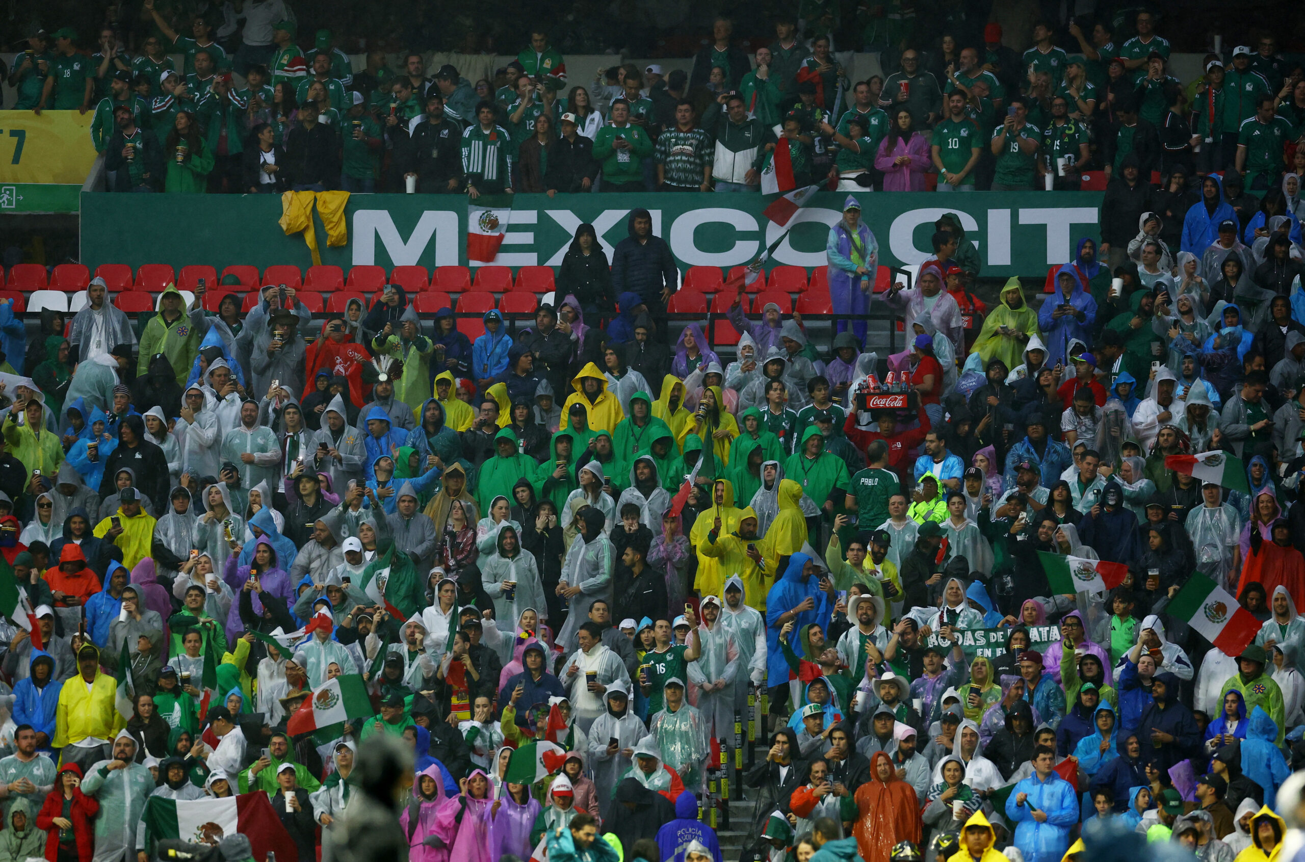 FIFA World Cup 2026 – Round of 16 – Mexico v England Soccer Football - FIFA World Cup 2026 - Round of 16 - Mexico v England - Estadio Azteca, Mexico City, Mexico - July 5, 2026 Fans wear rain ponchos inside the stadium before the match after kick off has been delayed due to the weather REUTERS/Daniel Becerril