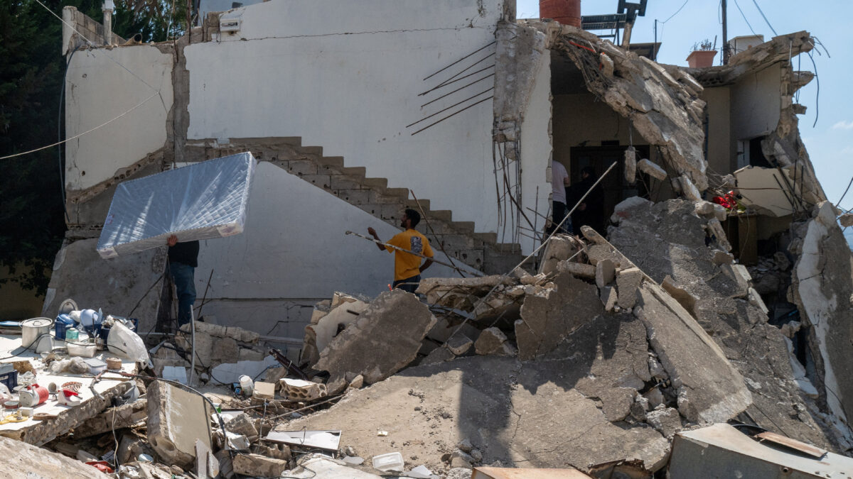 A displaced Lebanese man who survived an Israeli airstrike carries a mattress as he returns to his house damaged by an airstrike, following the U.S.-Iran deal, in Nabatieh, Lebanon, June 24, 2026. REUTERS/Zohra Bensemra