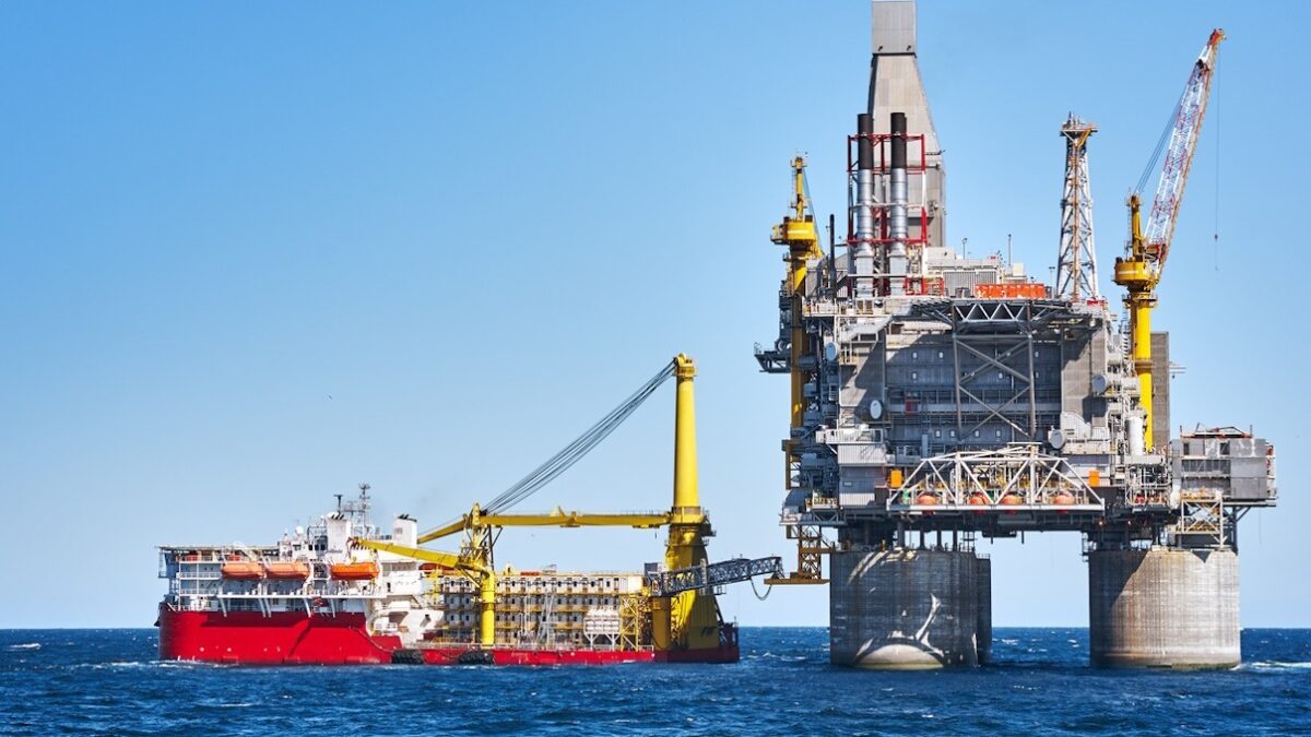 Oil rig and support vessel on offshore area near Sakhalin island. Blue sky background