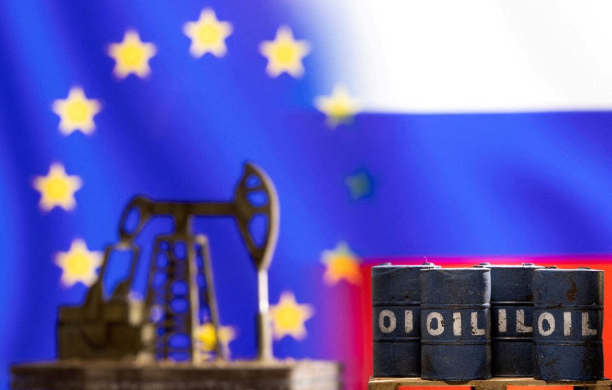 Βαρέλια πετρελαίου και μια αντλία μπροστά από τις σημαίες της ΕΕ και της Ρωσίας