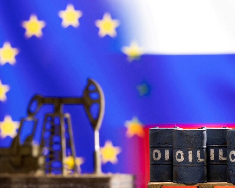 Βαρέλια πετρελαίου και μια αντλία μπροστά από τις σημαίες της ΕΕ και της Ρωσίας