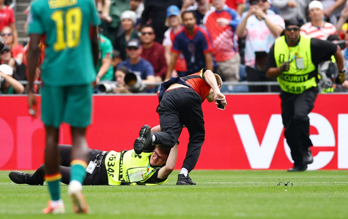 Soccer Football - FIFA World Cup 2026 - Round of 32 - Belgium v Senegal - Seattle Stadium, Seattle, Washington, U.S. - July 1, 2026 A security guard tackles a pitch invader who interrupted the match REUTERS