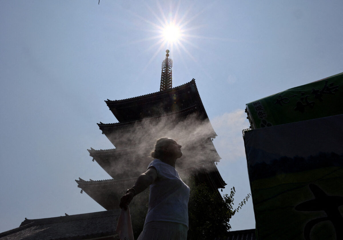 A visitor takes a break next to a cooling mist in front of a five-story pagoda at Sensoji temple, a popular sightseeing spot, as the Japanese government issued a heatstroke alert in Tokyo and other prefectures due to a heatwave, in Tokyo, Japan July 22, 2026. REUTERS/Issei Kato TPX IMAGES OF THE DAY