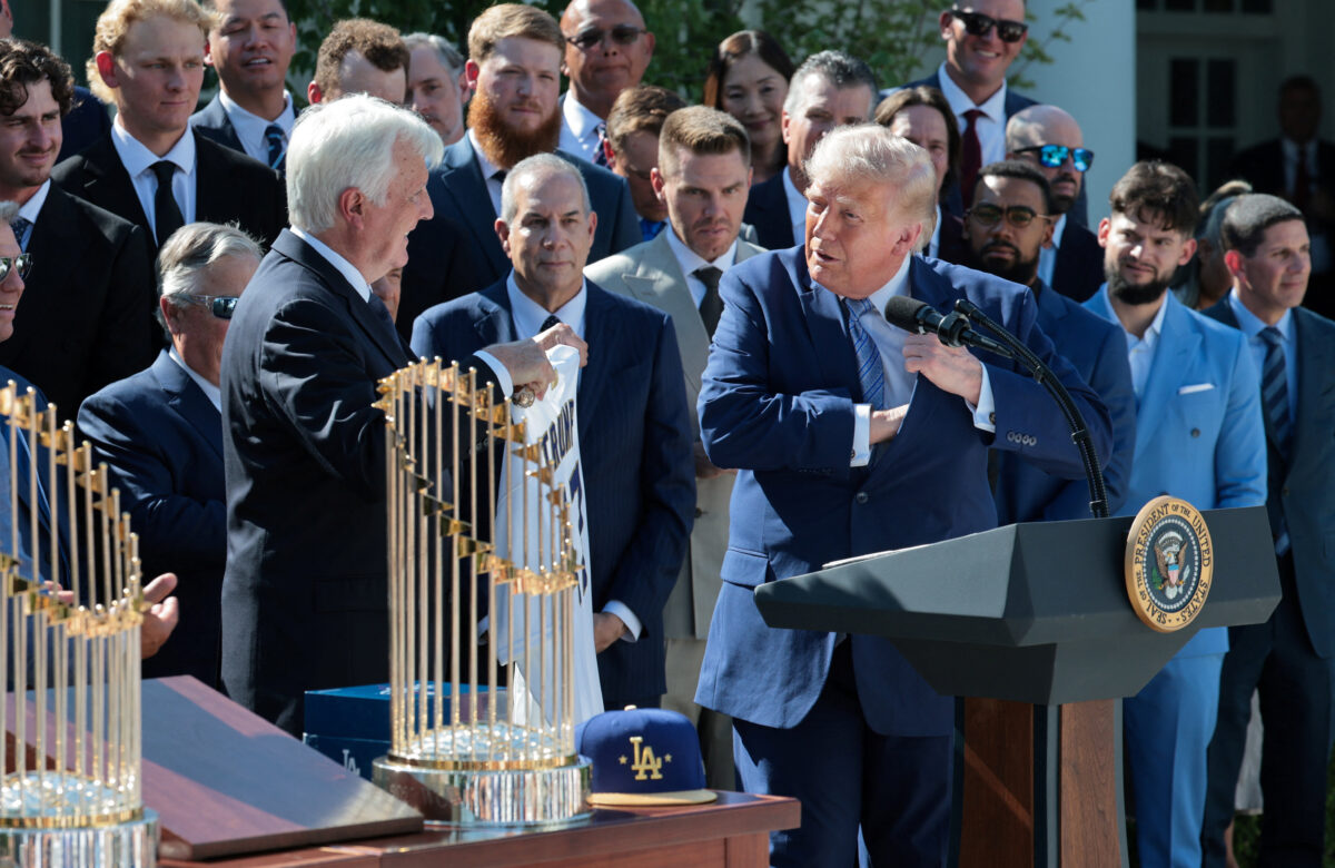 Mark Walter, CEO of Guggenheim Partners, gifts U.S. President Donald Trump a jersey with the number of his presidency, 47, during a reception for the reigning Major League Baseball (MLB) World Series champion Los Angeles Dodgers in the Rose Garden at the White House, Washington, D.C., U.S., July 23, 2026. REUTERS