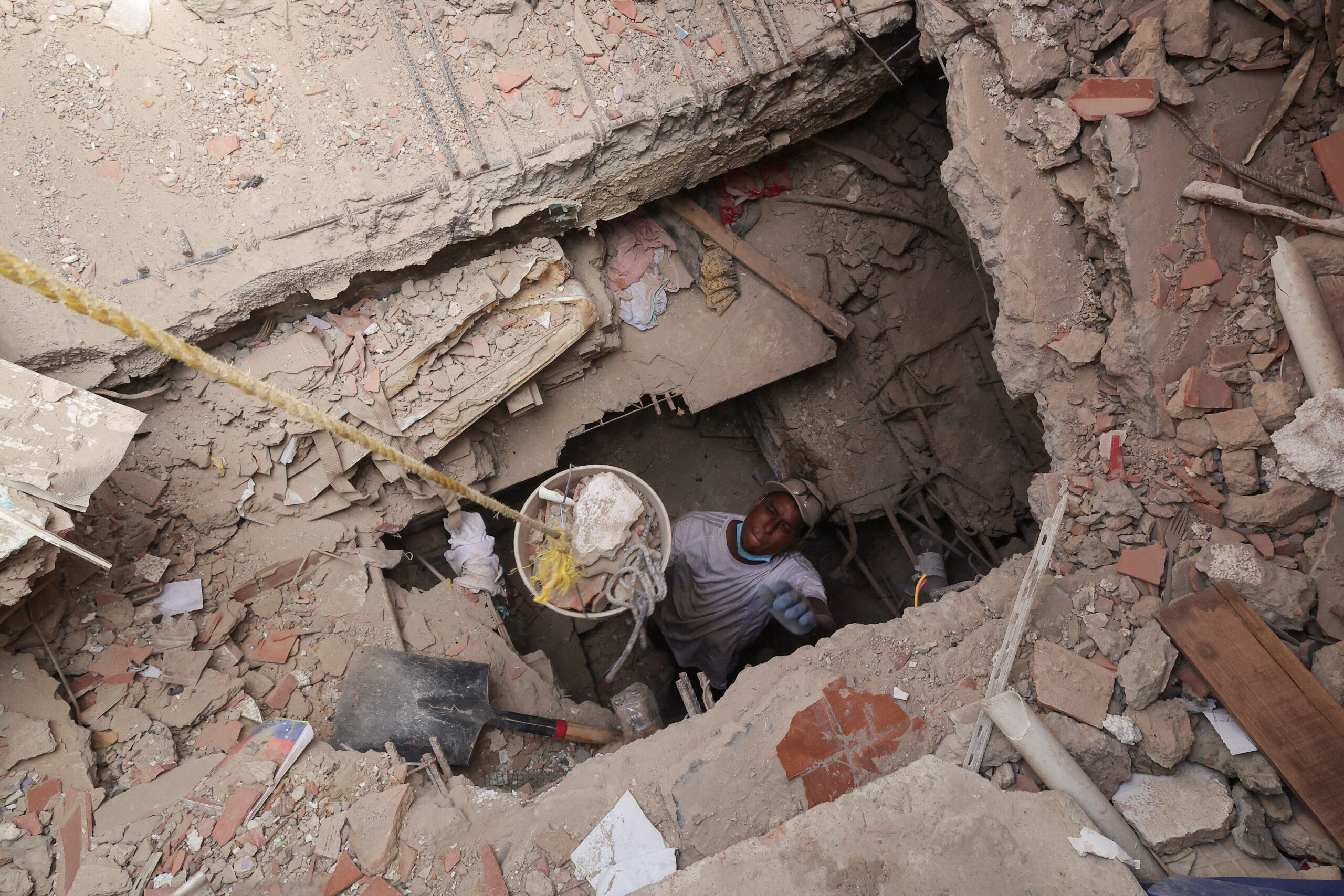 Armando Ceballos looks for his grandmother and uncle after digging a tunnel trying to get to the first floor of where his grandmother lived, in the aftermath of the June 24 earthquakes in La Guaira, Venezuela, July 17, 2026. REUTERS
