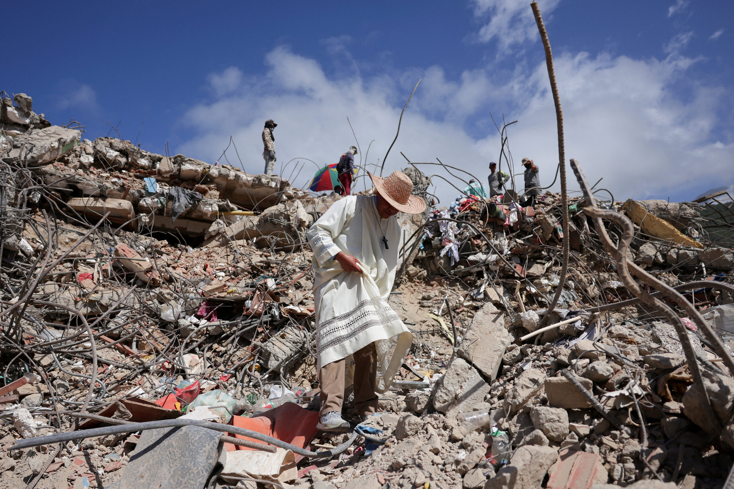 A priest walks through the debris of a collapsed building in the aftermath of the June 24 earthquakes in La Guaira, Venezuela, July 17, 2026. REUTERS