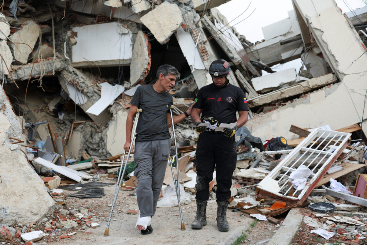 Francisco Soto, a survivor of the June 24 earthquakes, shows his rescuer Gabriel Echenique some documents he found in the rubble of his apartment, as he returns to look for documents and other valuables, in La Guaira, Venezuela July 12, 2026. REUTERS