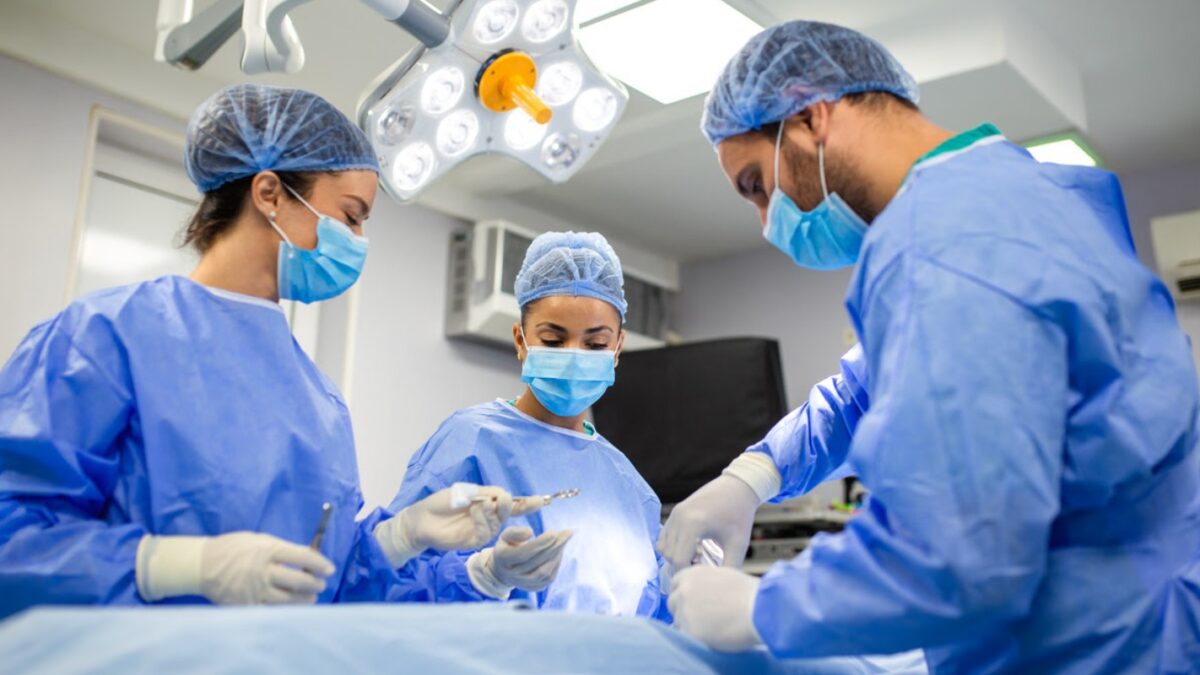 Surgeons and assistants working together during surgery. Medical team in sterile scrubs performing a procedure under bright operating lights. SSUCv3H4sIAAAAAAAACpySz27CMAzG75P2DlXOVKK0hYZXQTu4TqARIUFJyjQh3n350yLvulv9s/3ZX9zn50dVsRG8QnasnimKsdJ69sFBUNZEvN0s3EkjpKPk4dr9lgJQNJJCBesUaApHCDgZuMkIzax1wq+cZD5AmL30aZcFIQR5iRoFviXKwqcSV2siJ2NHTDG2IczPY2YrKuL/6iwfX2/DF2nwJy9MjDipJRQjp1LKrt9Buhu1BrNQlrh6WASdClqiBOoODv703Z1CZS6E2DDlu6xKaGcTXNrqbYZpa+8w6vTq5zhGrnwC72O5WDmZjfEvsDcyx9iQPS2qTMTjpLBpW973hz0fmq7rh47zpaAcdFJRJ6+zCsUYr0pQVyptwEYcdrumx5pjK+pObHk9nAXUKA9CNru2EcjjLV6/AAAA//8DADMgluq5AgAA