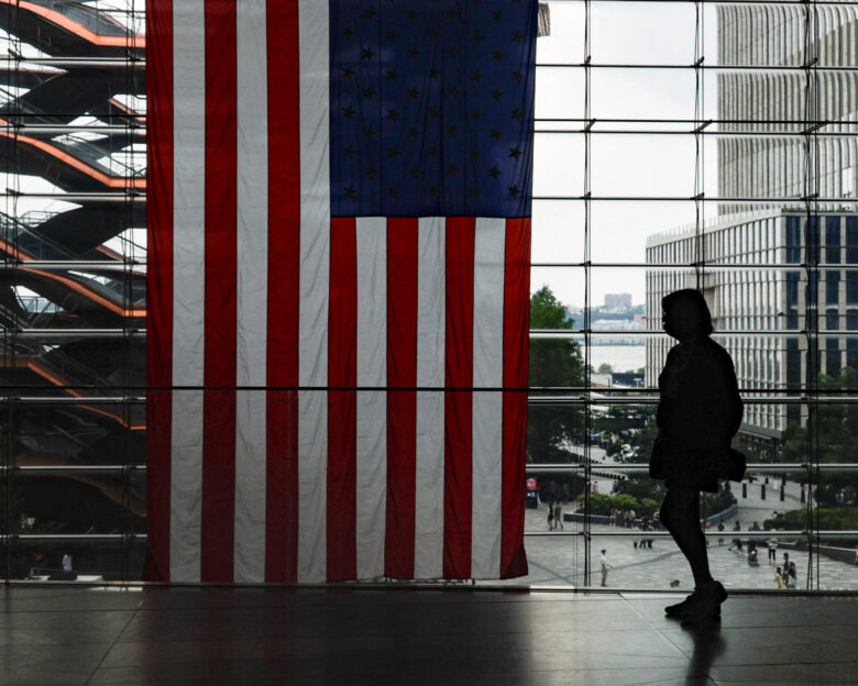 A shopper walks past a U.S. flag at Hudson Yards in New York City, U.S., July 27, 2026.