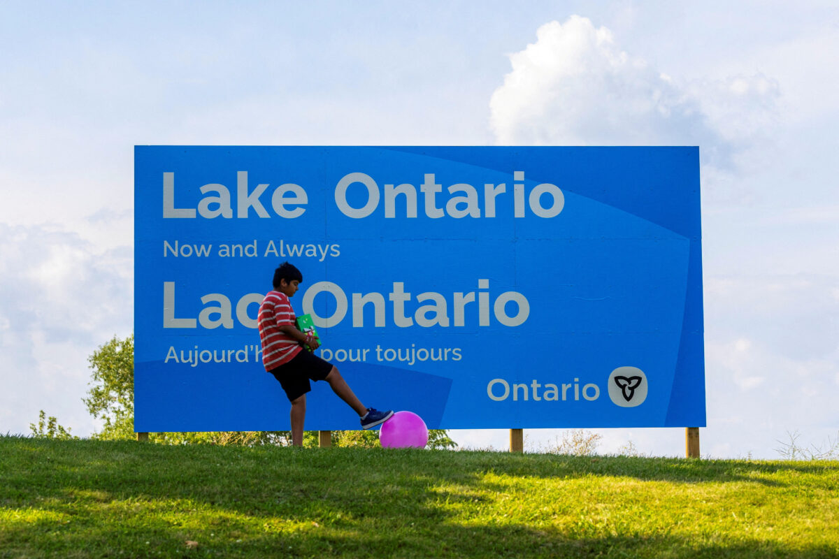 A young child plays with a ball near a sign reading "Lake Ontario, Now and Always," unveiled by Ontario Premier Doug Ford at Fifty Point Conservation Area, after U.S. President Donald Trump signed an executive order renaming Lake Ontario as "Lake America," near Grimsby, Ontario, Canada, August 29, 2026. REUTERS