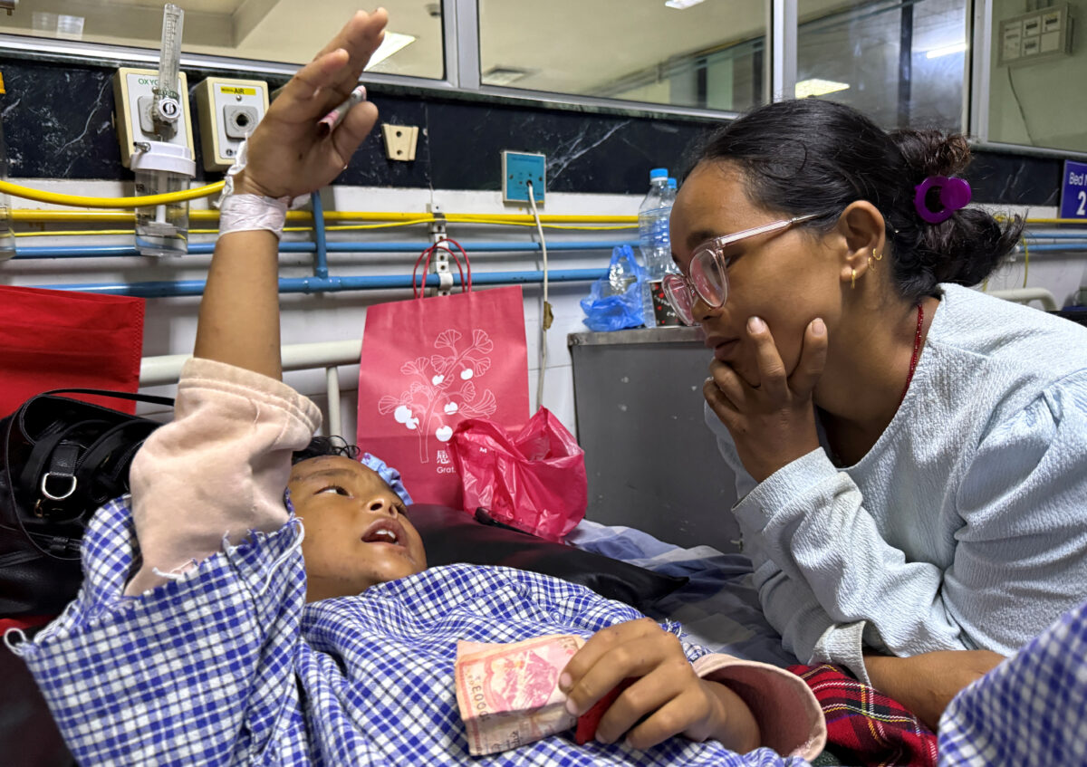 Zoyal Ghale, 8, who was airlifted from Rasuwa after being injured in the deadly flash floods and mudslide, speaks with his mother Matti Maya Tamang, 28, two days after they were separated following the floods, inside a hospital in Kathmandu, Nepal, August 28, 2026. Picture taken with a mobile phone. REUTERS