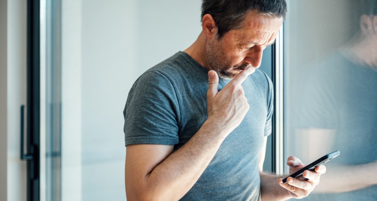 Reading worrying text message on mobile phone, selective focus