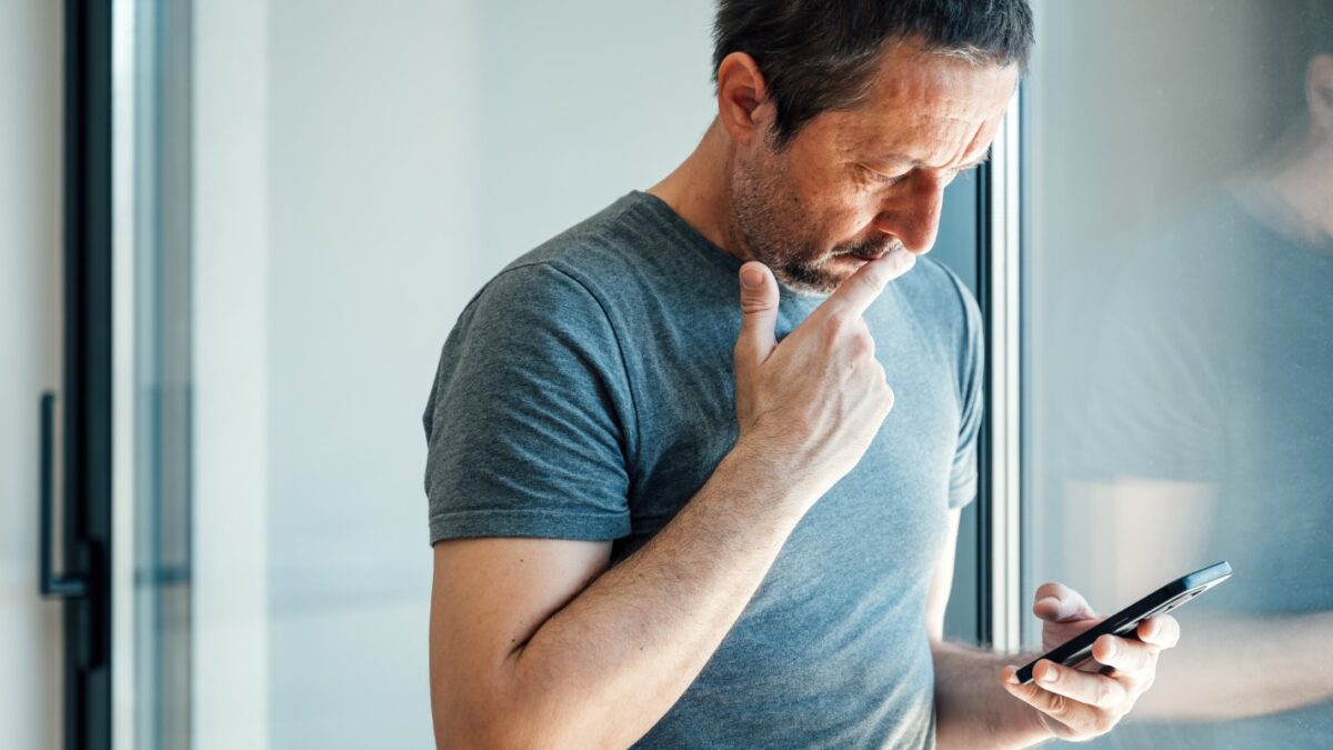 Reading worrying text message on mobile phone, selective focus
