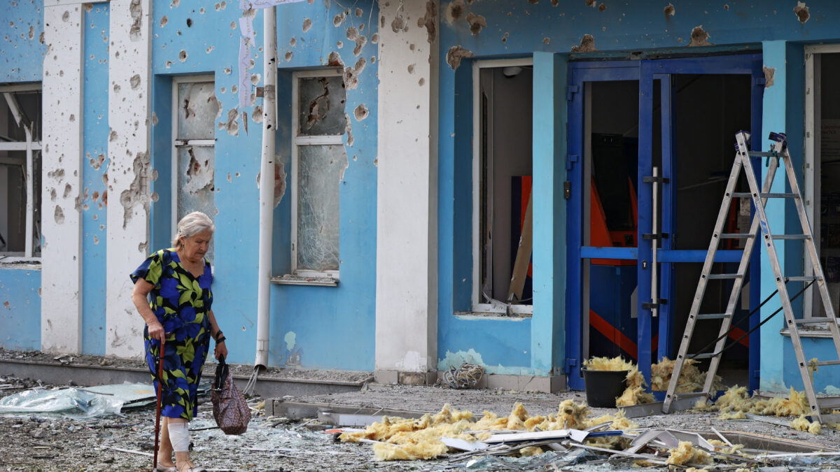 A woman walks past a bank building damaged during a Ukrainian overnight drone attack, according to local authorities, in the course of Russia-Ukraine conflict, in Belgorod, Russia August 9, 2026. REUTERS/Stringer