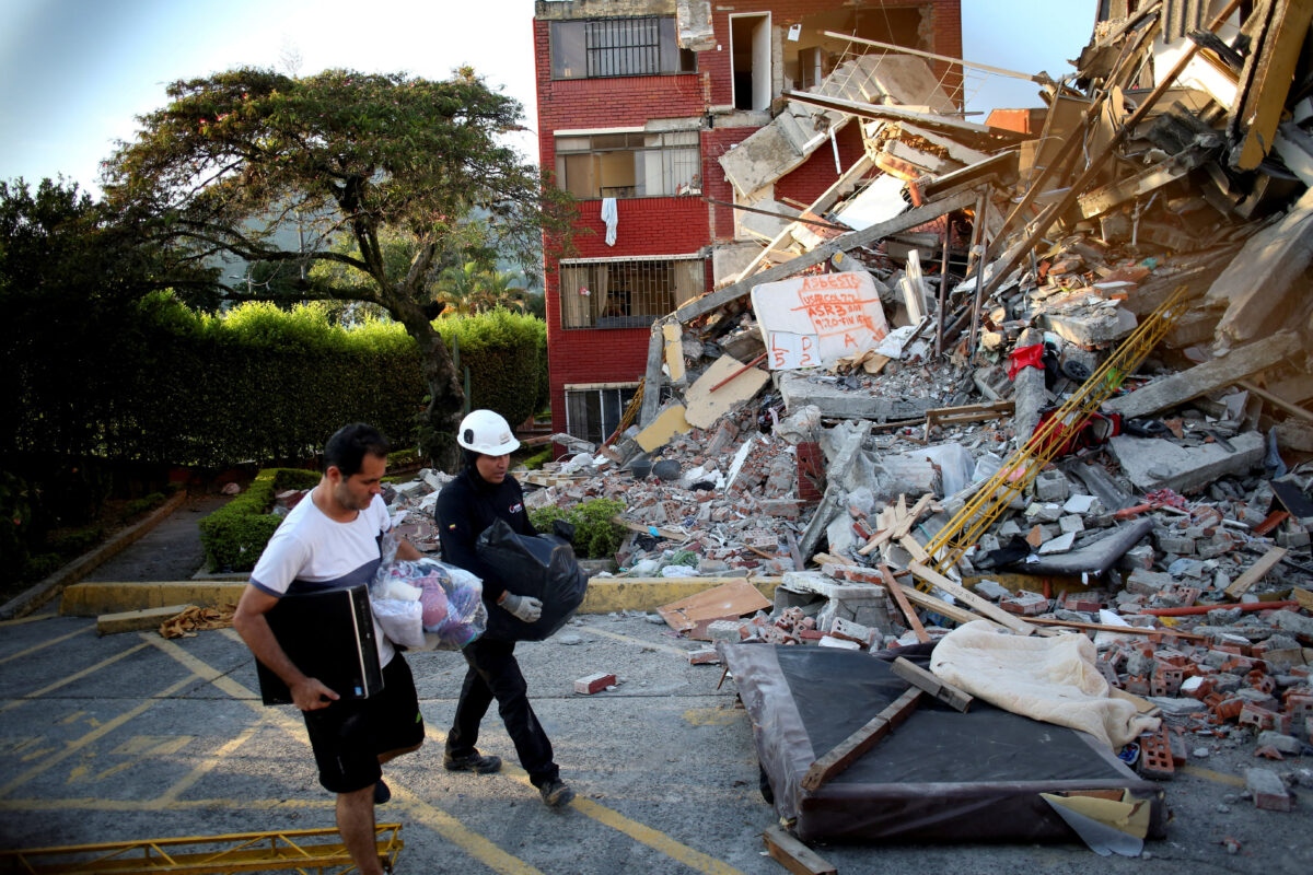 People walk past debris following an earthquake, in Pereira, Colombia, August 11, 2026. REUTERS