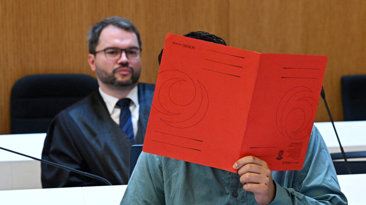Lawyer Johann Bund and defendant Farhad N., accused of murder and other charges, arrive for his verdict in a courtroom in Munich, Germany, August 6, 2026. REUTERS/Angelika Warmuth
