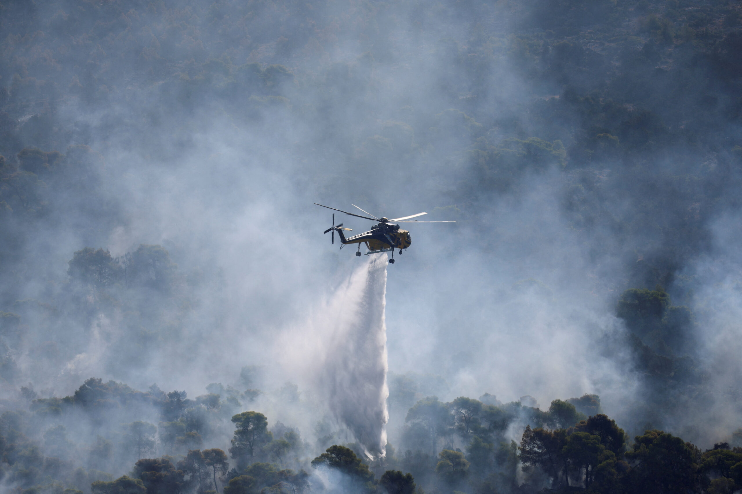 Wildfire burns in Greece An Erickson firefighting helicopter makes strategic water drops as a wildfire burns in Mount Kitheronas, near Psatha, west of Athens, Greece, August 3, 2026. REUTERS/Louisa Gouliamaki REFILE - CORRECTING LOCATION FROM