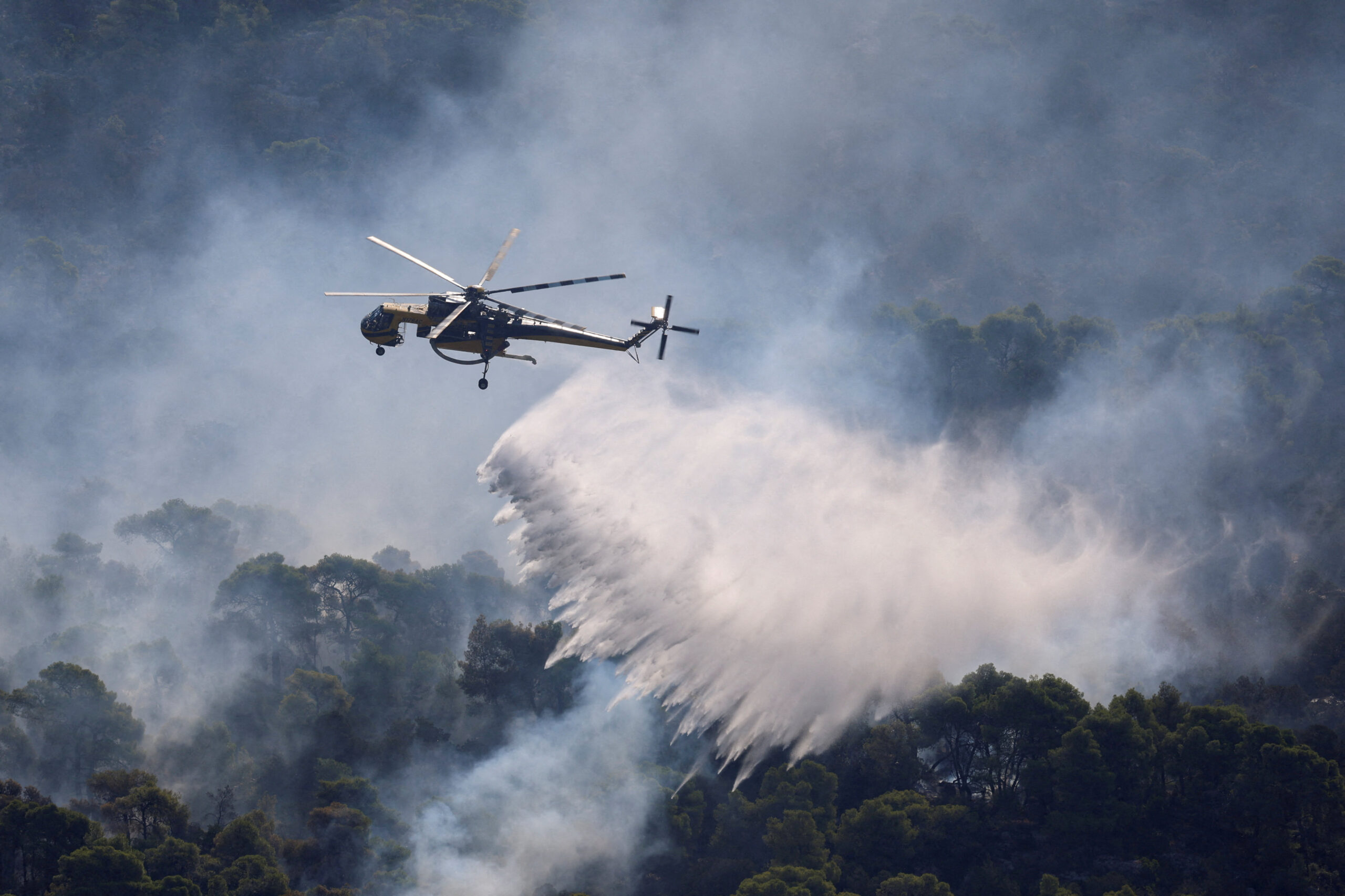Wildfire burns in Greece An Erickson firefighting helicopter makes strategic water drops as a wildfire burns in Mount Kitheronas, near Psatha, west of Athens, Greece, August 3, 2026. REUTERS/Louisa Gouliamaki REFILE - CORRECTING LOCATION FROM
